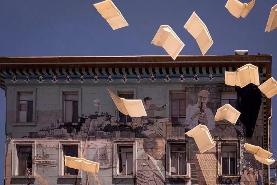 贝博体彩app城市之光书店的外景，展示了一幅由书籍和漂浮纸张组成的壁画.