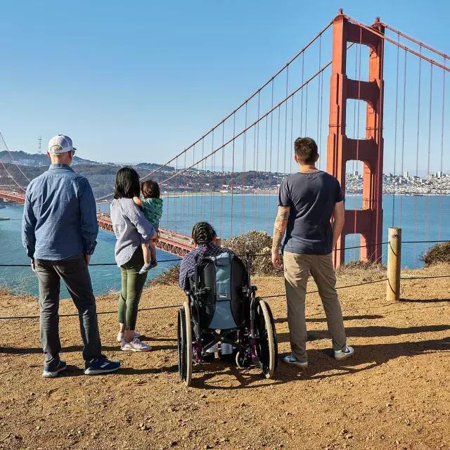 一群人, 包括一个坐轮椅的人, 当他们从马林海岬看金门大桥时，从背后看到的是什么.